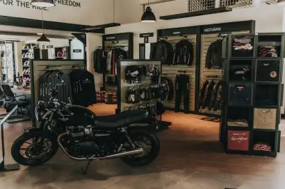 Motocicleta no interior da loja com jaquetas ao fundo 2